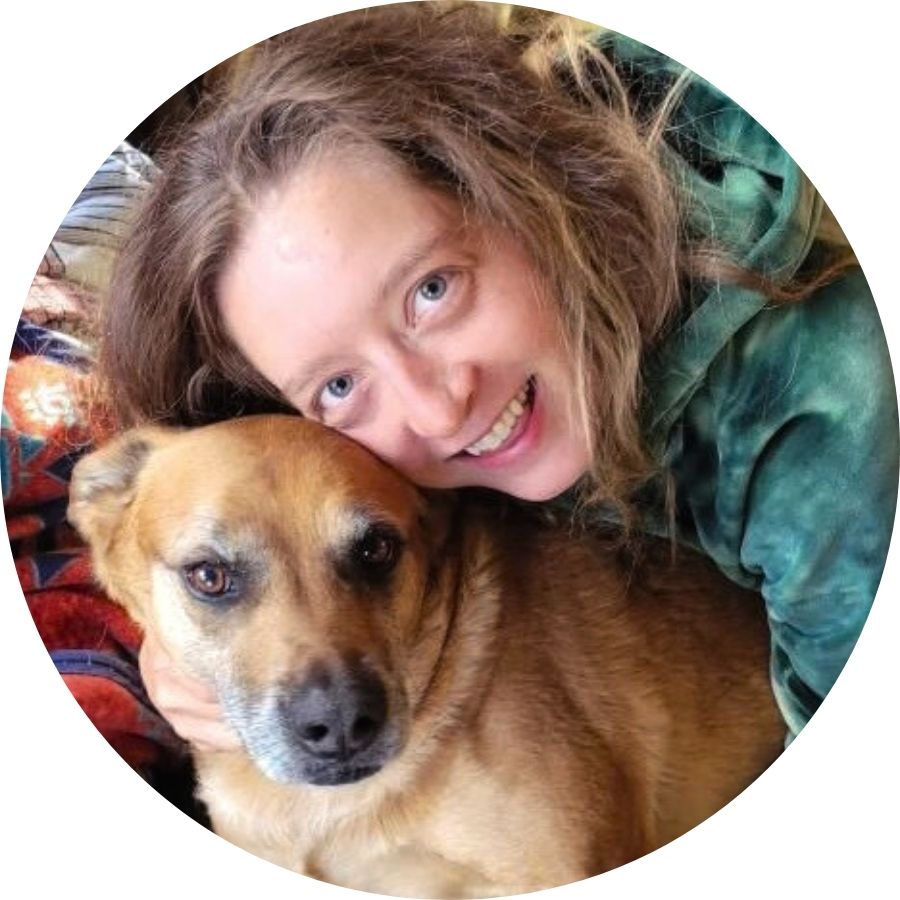 Andrea smiling with a tan dog